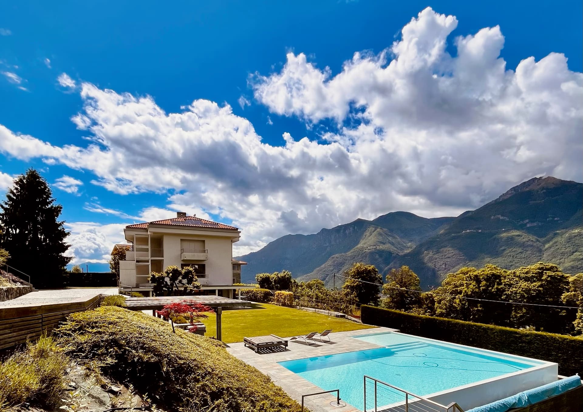 Villa Panoramica — vista esterna con piscina a sfioro sulle Prealpi